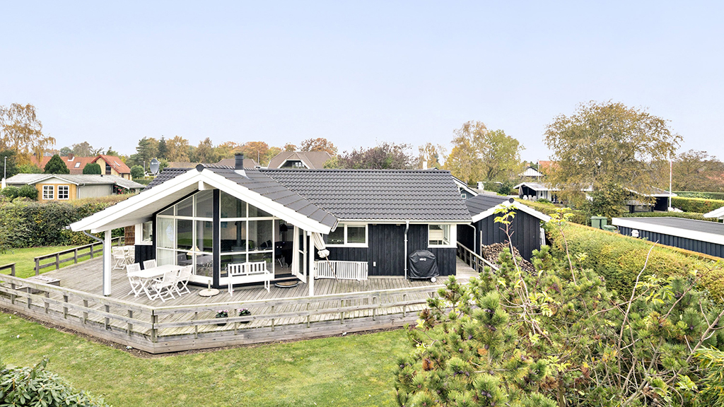 Black summer house with a garden and terrace