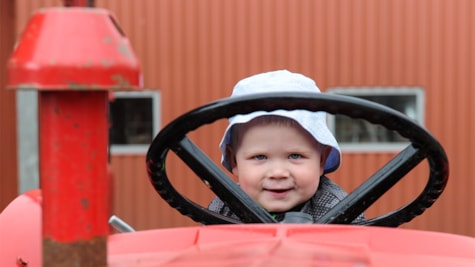 Хлопчик сидить на тракторі в музеї Фергюсона в Данії