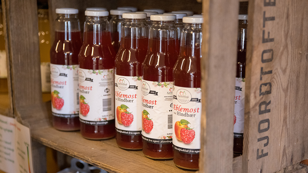 Bottles of homemade apple juice are standing in an old fruit crate at Karensminde Frugtplantage