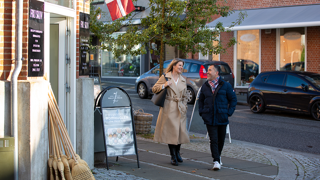 A woman and a man walk on Bredgade in Brædstrup near Fru Skov