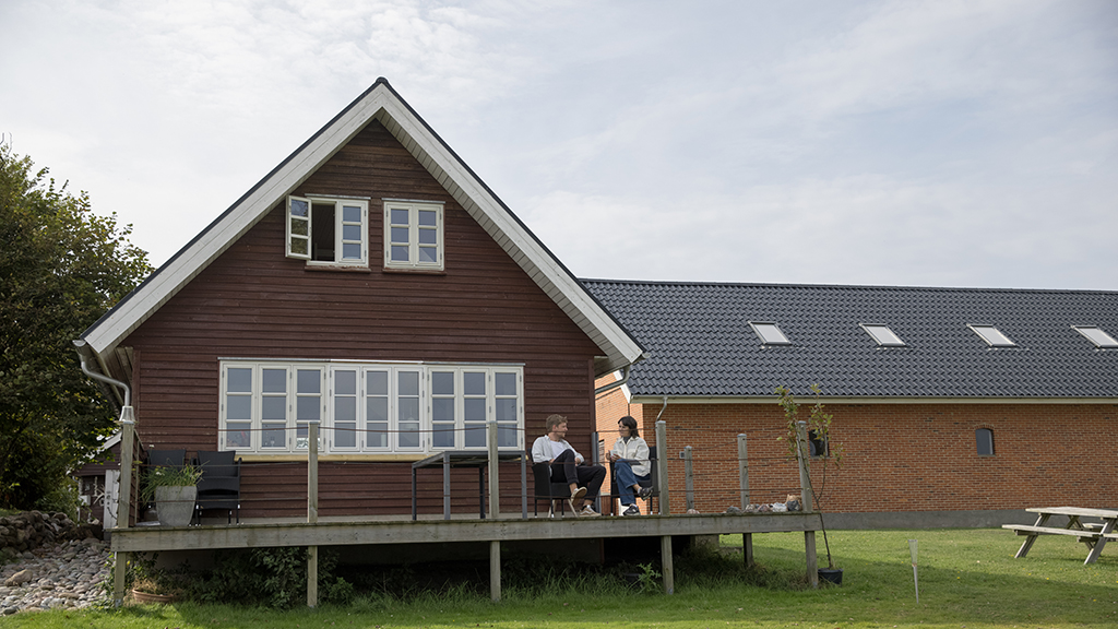 A couple sitting on the terrace of Kærhuset