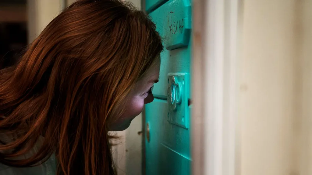 Kvinde ser gennem kighul i celledør på Fængselsmuseet i Horsens