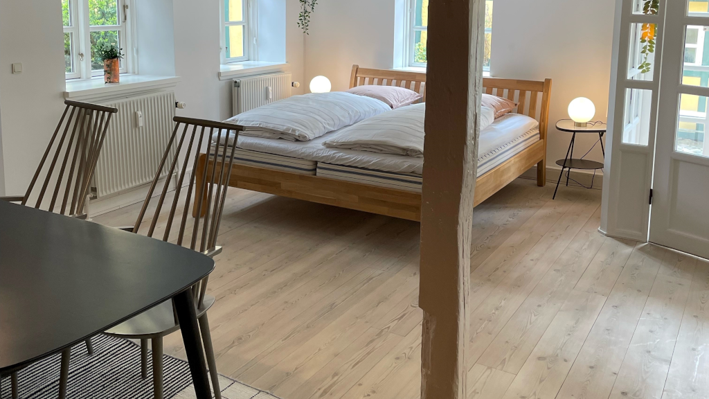Bed and dining area in the Sidehuset at Bødkergaarden B&B in Horsens