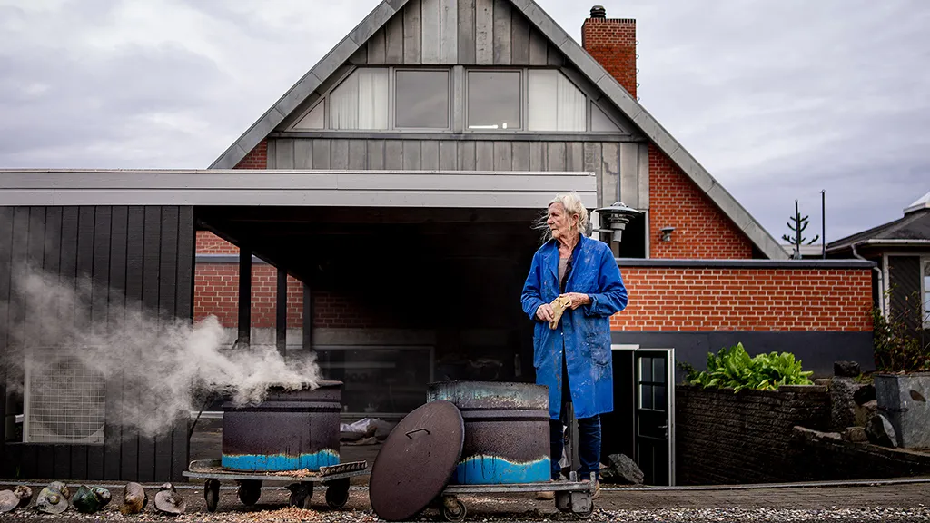 The owner of Eva Keramik stands in front of the shop and workshop at Rude Beach