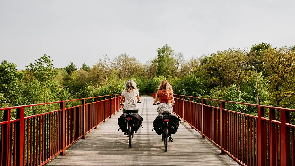 To kvinder cykler på elcykler på Den Genfundne Bro i Horsens