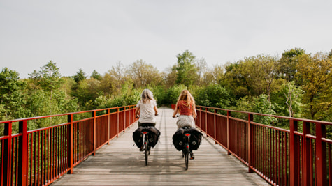 To kvinder cykler på elcykler på Den Genfundne Bro i Horsens
