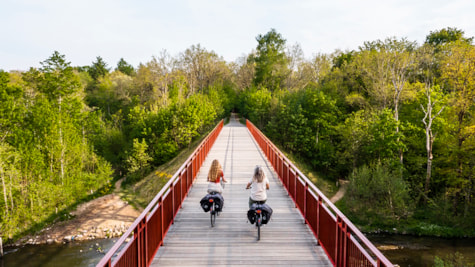 Luftfoto af Den Genfundne Bro, mens to kvinder cykler på elcykler.