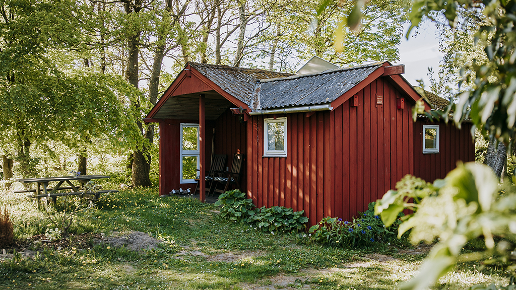 A red-painted annex surrounded by trees at Holmely