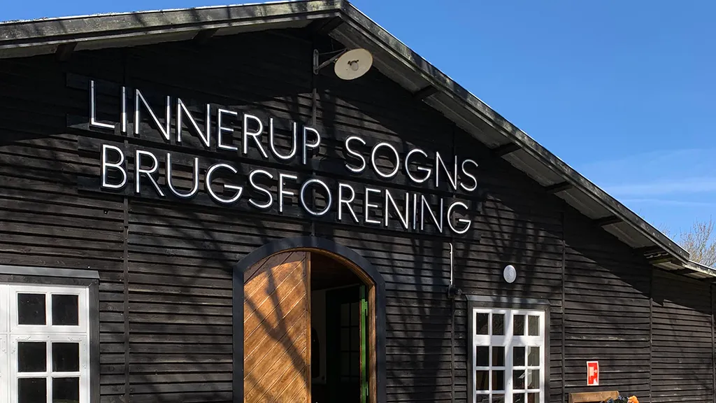 Gammel brugsforening med terrasse og blå himmel ved Hjortsvang museum frilands nær Uldum og Gudenåen