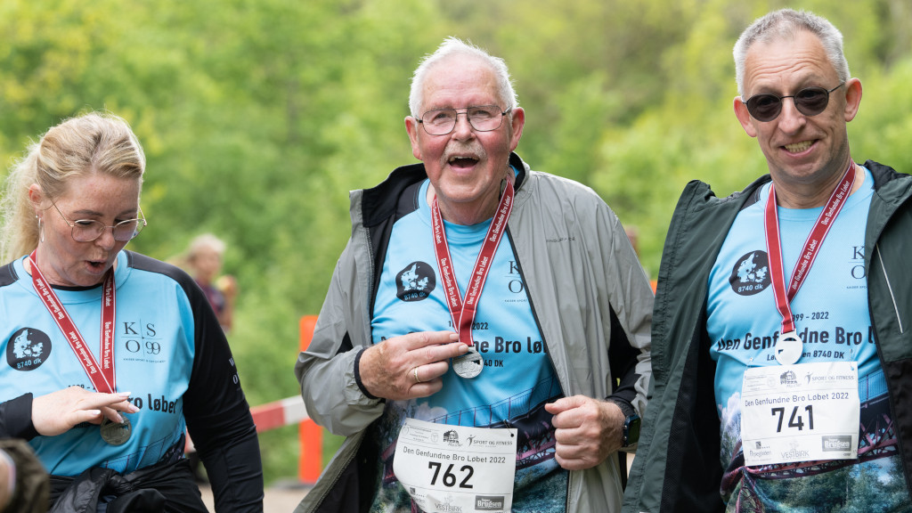 Older men and a woman with medals from Den Genfundne Bro Løbet