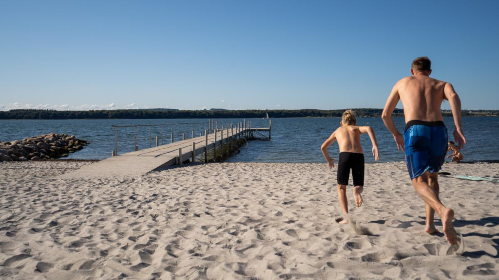 A father and son racing towards the water at Husodde Beach