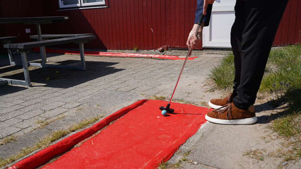 A man hits a golf ball at the mini golf course in Saxild