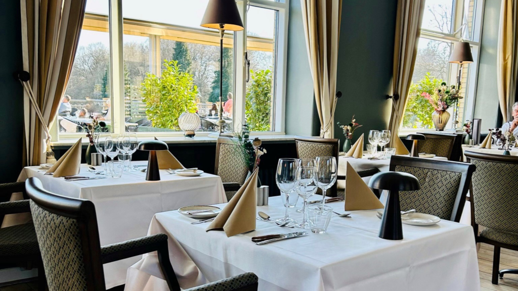 Set tables in the restaurant at Hotel Vejlefjord