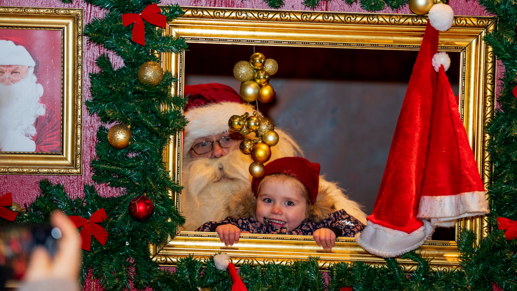 Santa Claus and a little girl are looking through a frame at the Christmas market 'Jul på FÆNGSLET' in Horsens