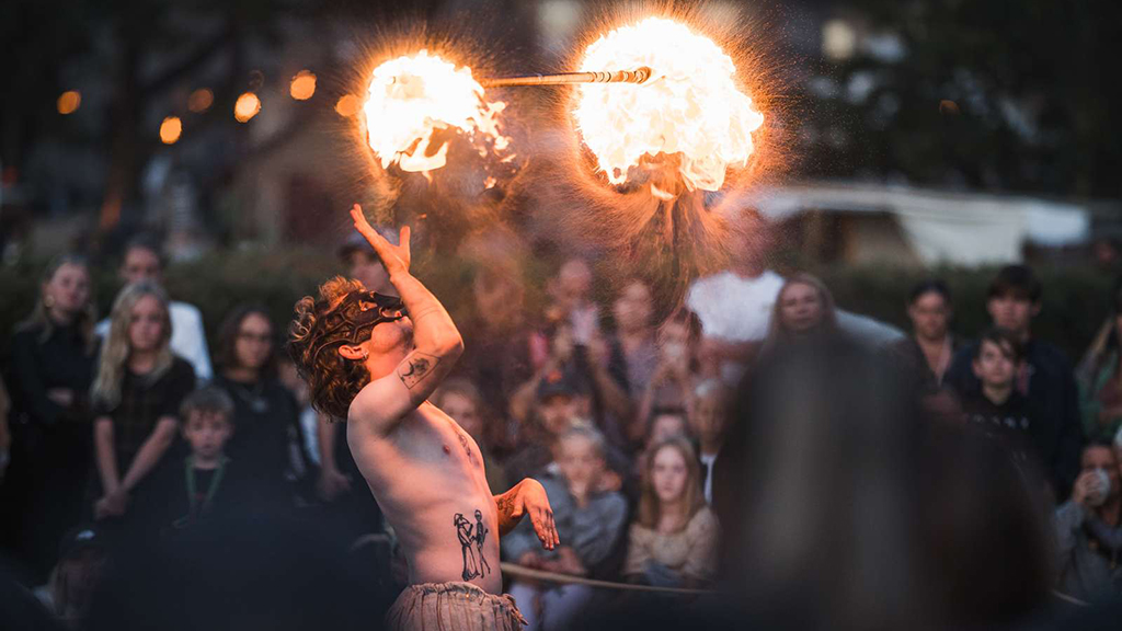 A man wearing a mask is throwing fire at the Horsens Medieval Festival