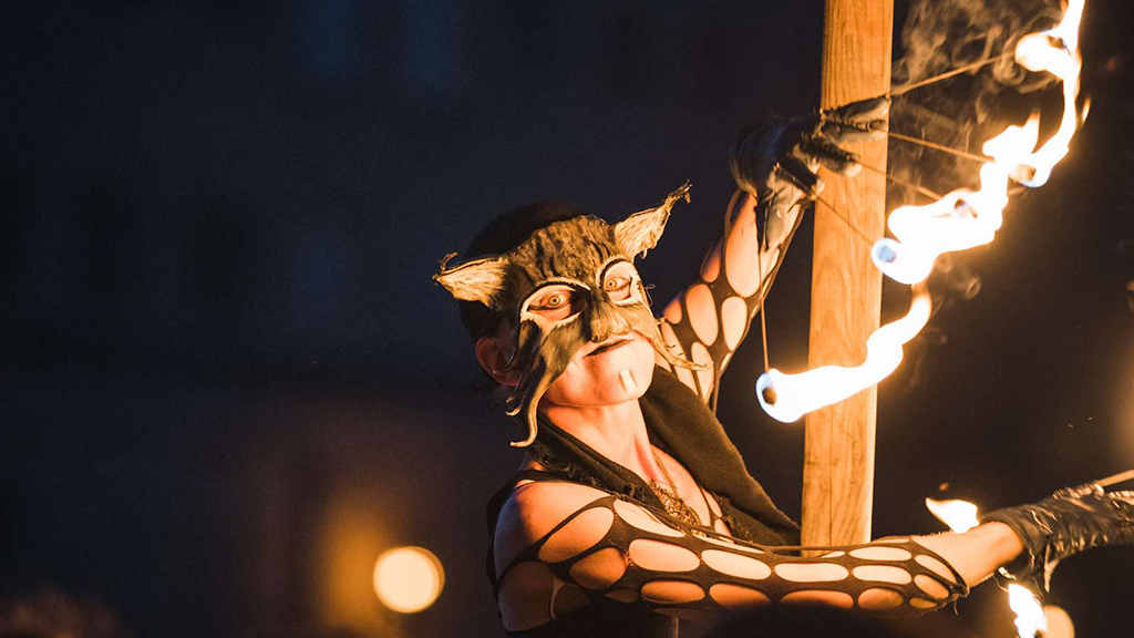 A woman wearing a mask performs with fire at the Horsens Medieval Festival