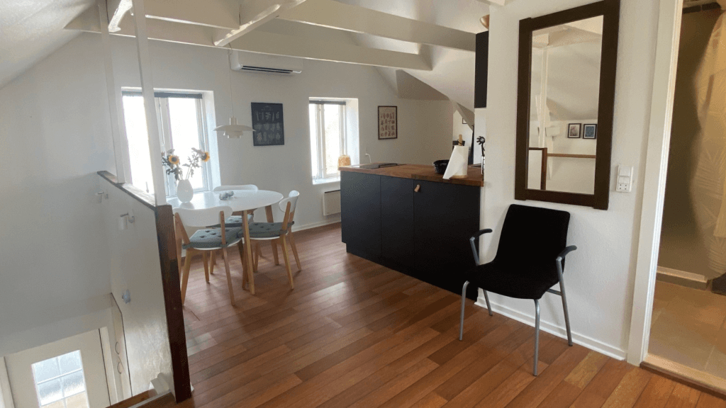 Staircase and kitchen in the apartment at Holsteinshus B&B in Odder