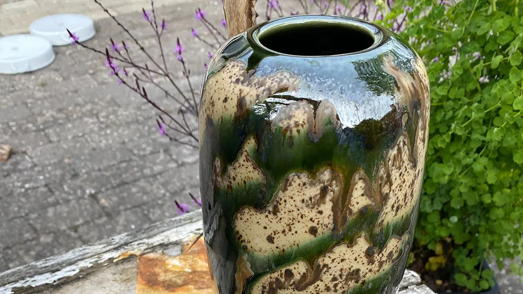 A large stoneware pot in green-marbled and beige colours