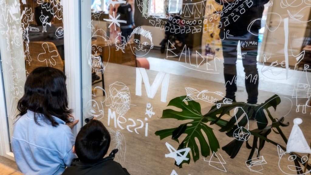Children are drawing on a window for the Makværk Festival in Horsens