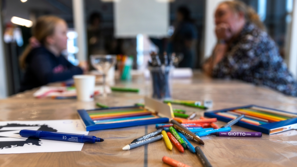 A girl and a woman are sitting at a table with colored pencils for the Makværk Festival in Horsens