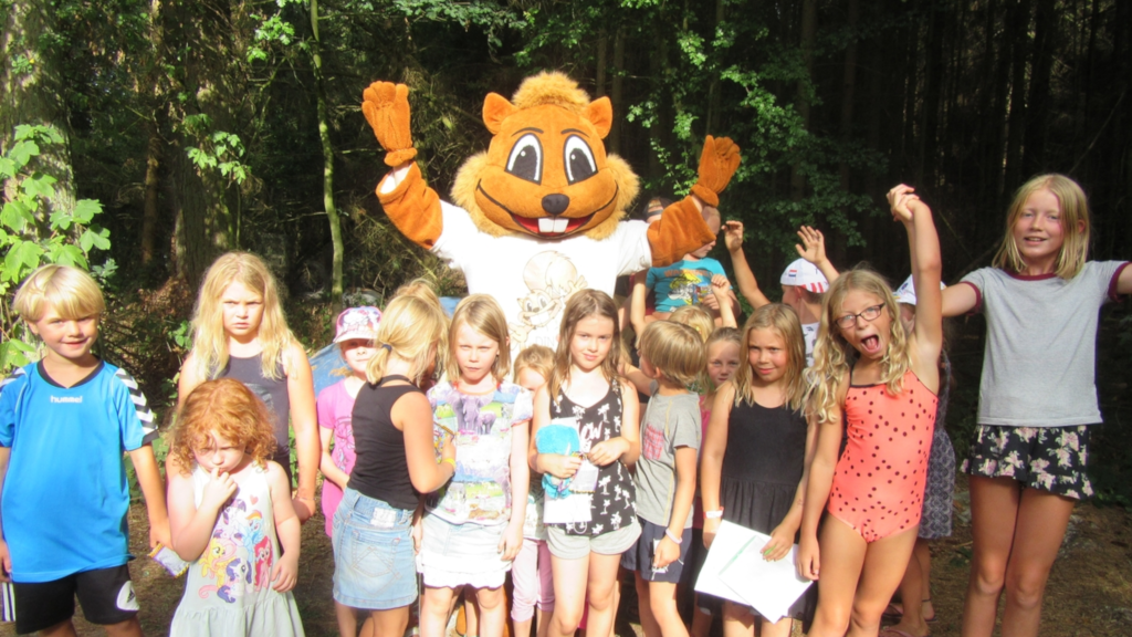 Children standing with a squirrel mascot at Vestbirk Camping.