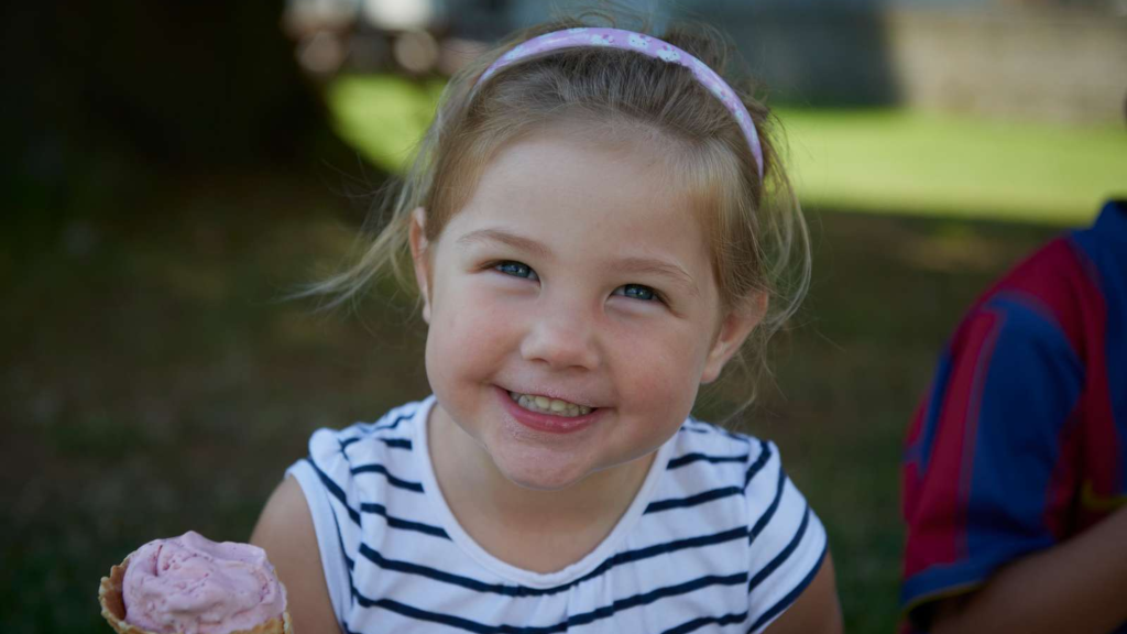 Smiling girl with an ice cream cone at Vestbirk Camping.