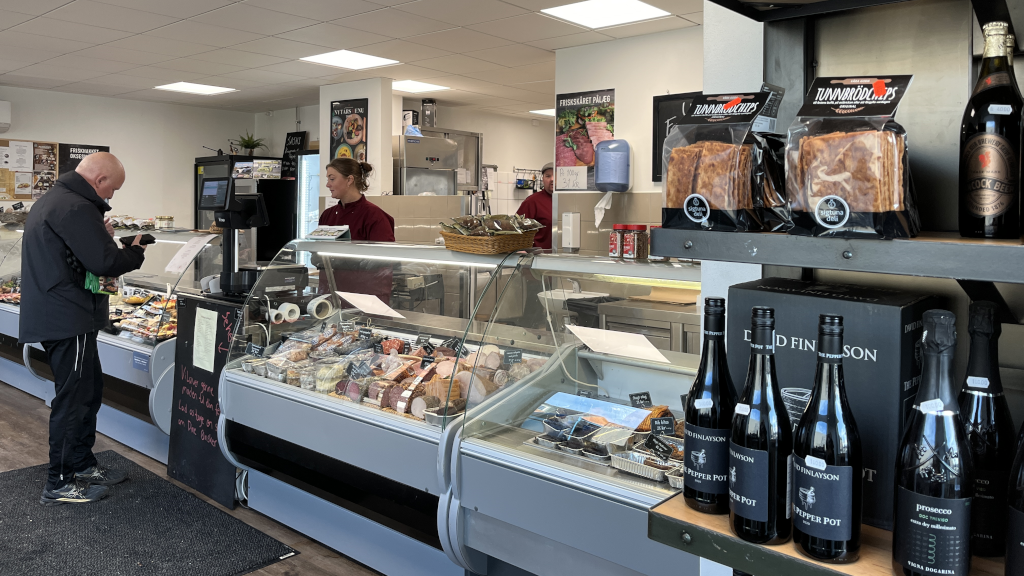 Wine on the shelves and customers in the shop at Slagter Laursen in Brædstrup