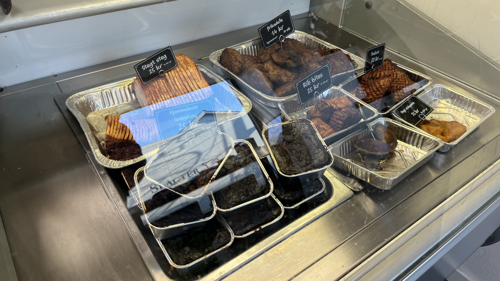 Meatballs, fish fillet, warm liver pâté, sausage, and pork roast in the display case at Slagter Laursen