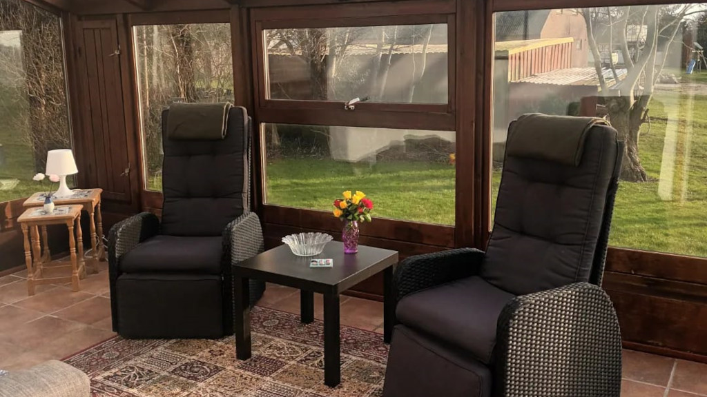 A sunroom with two armchairs at Mitlandidyl