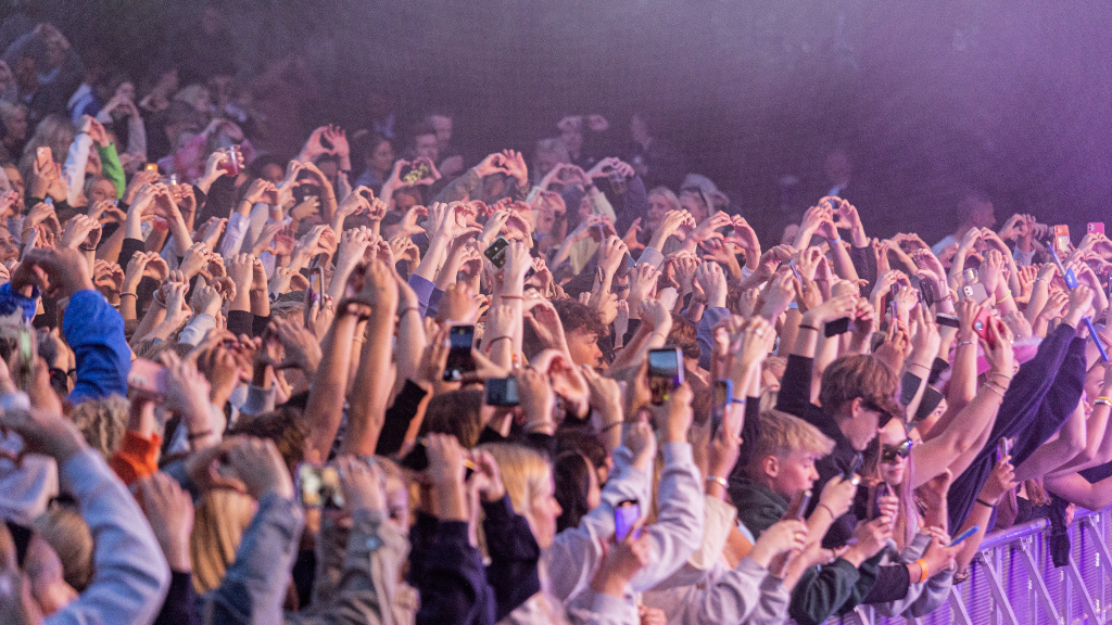 The audience makes heart shapes with their hands at the concert in Lunden in Horsens