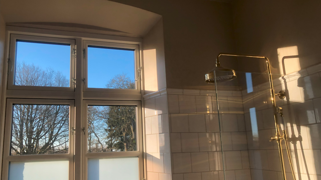 A brass shower in the bathroom at Reballegaard