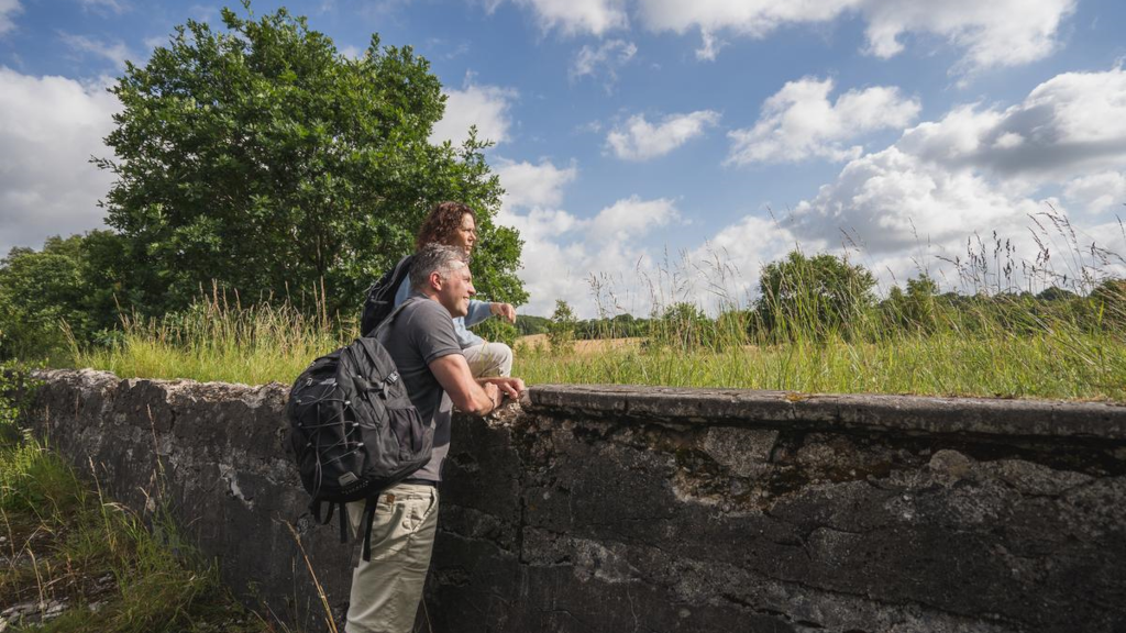 A couple is standing by the remains of an old water park in Tinnet Krat