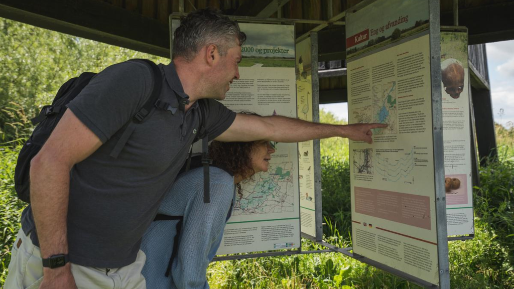 A man points at a sign in the birdwatching tower at Uldum Kær