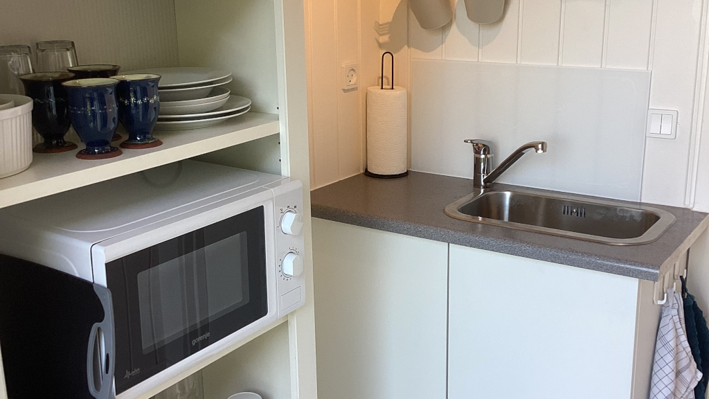 Kitchenette with a sink, microwave, and tableware at Anneks127