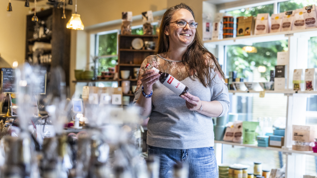 Eine Frau hält eine Flasche Bruun Kola im Geschäft Spisekammeret