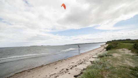 En kitesurfer ved stranden ved Borre Knob