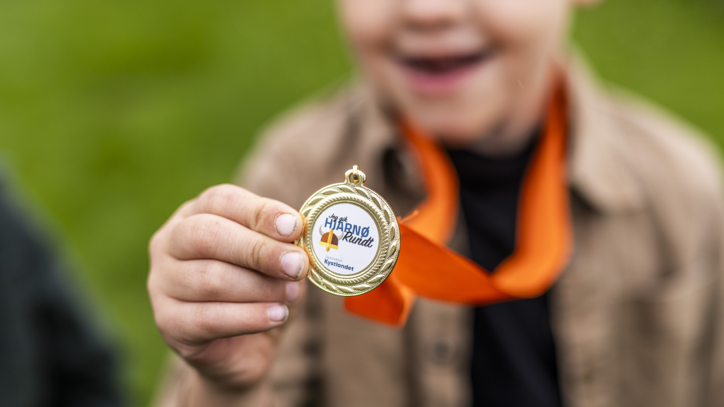 Boy showing off a medal from the Hjarnø Treasure Hunt
