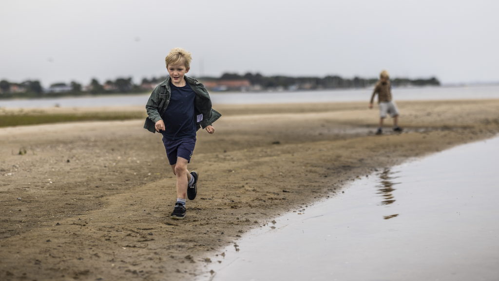 Two boys running on a beach on Hjarnø