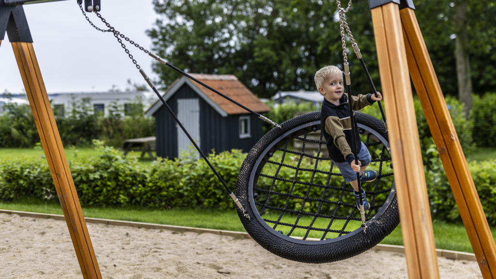 Boy swings at the playground at Hjarnø Camping