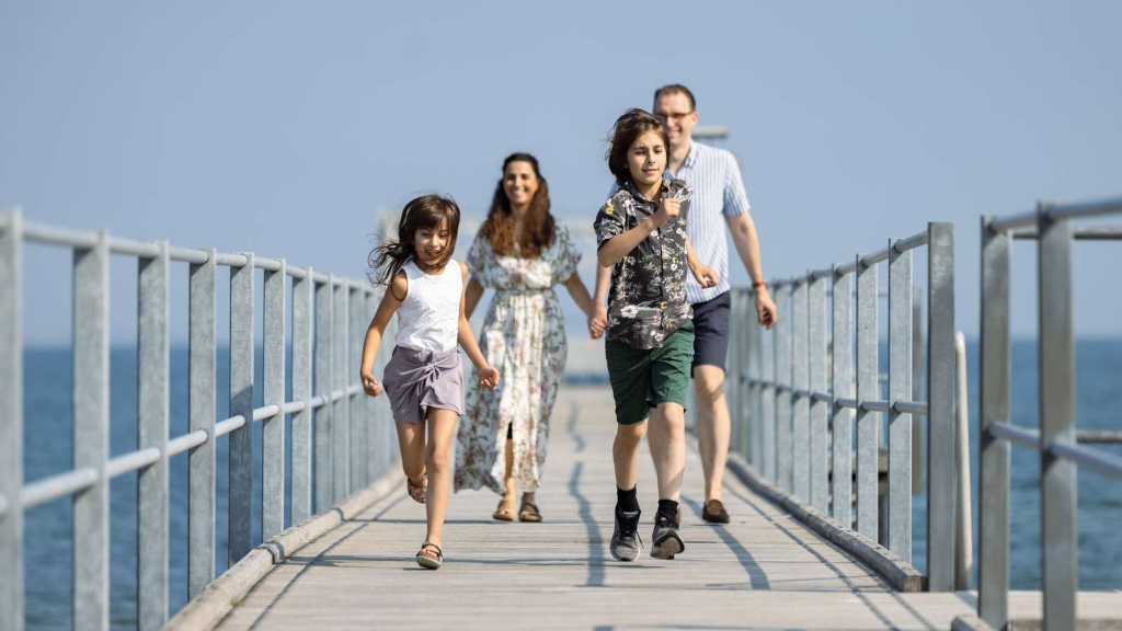 A family walking on the bathing jetty in Hou