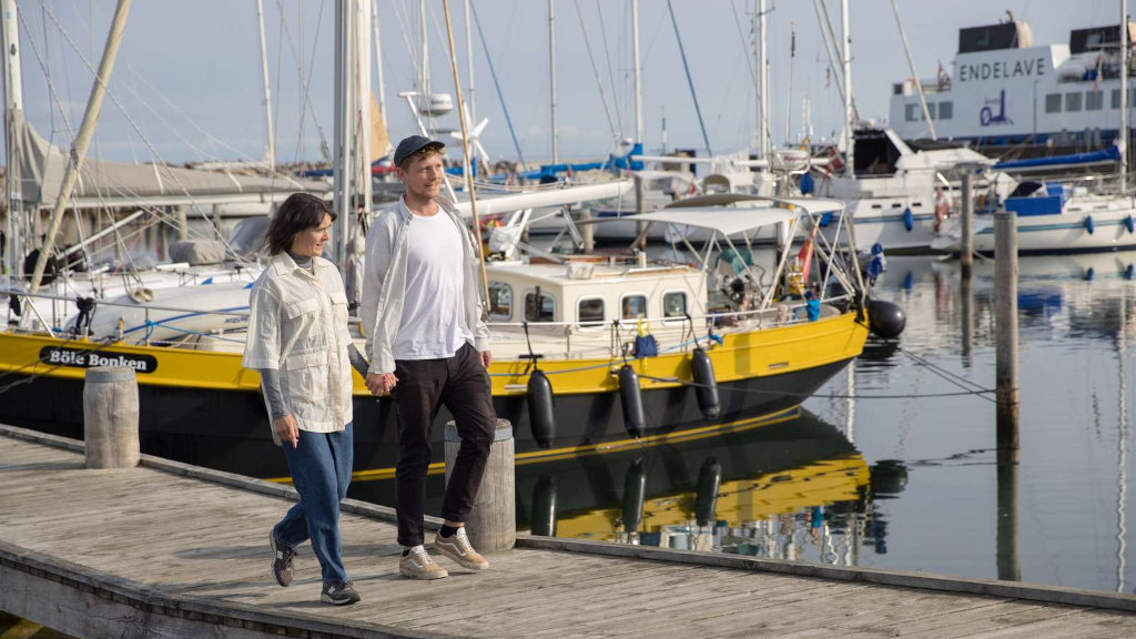 A couple walking on a dock on Endelave Marina