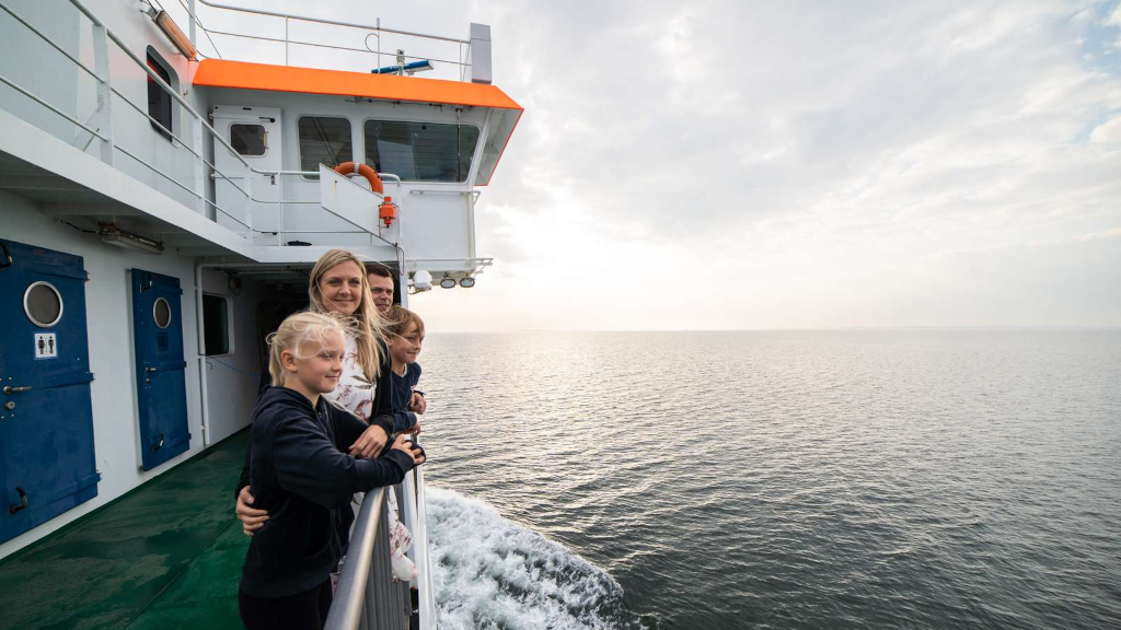 A family enjoys the sea view over the railing on the Endelave ferry