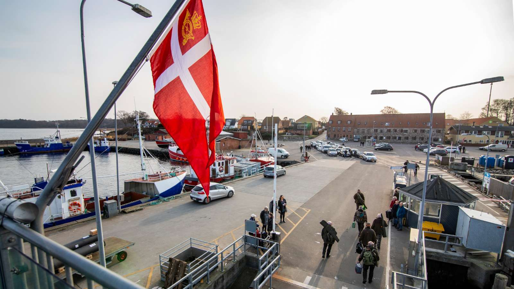 The Danish flag is raised on the Endelave ferry as passengers disembark