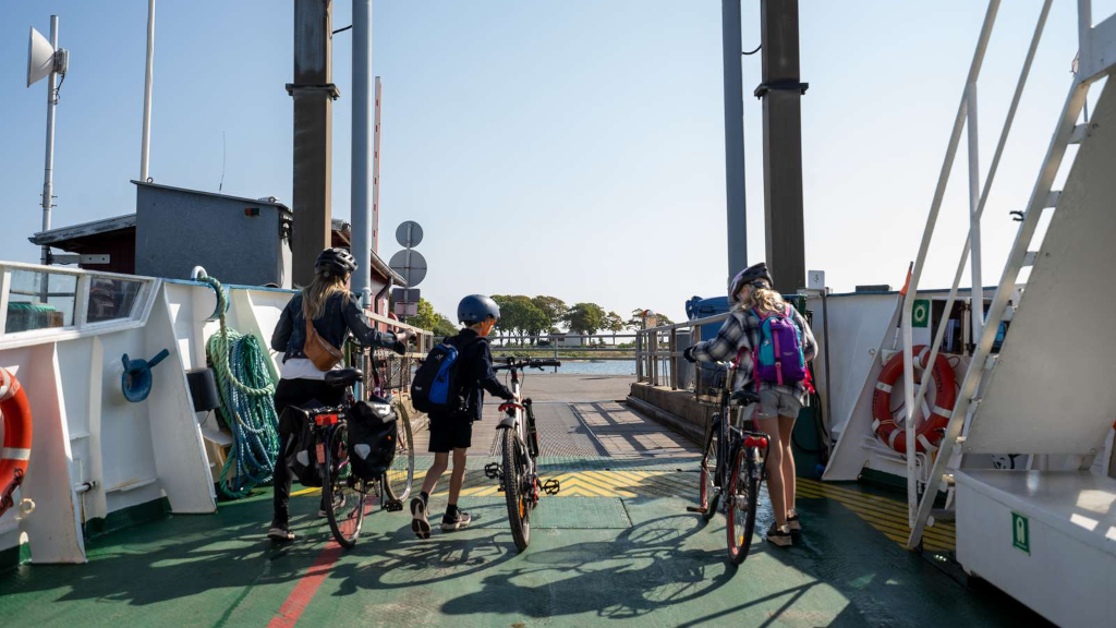 A family is unloading their bikes from the Hjarnø Ferry