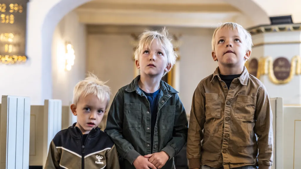 Drenge kigger på udsmykningen i Hjarnø Kirke