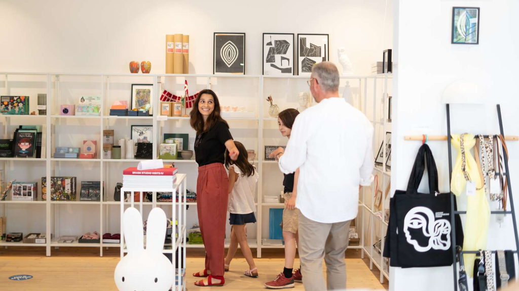 En familie kigger på produkter i butikken hos Horsens Kunstmuseum