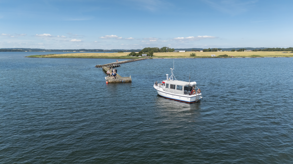Drone photo of the Alrø-Hjarnø Bicycle Ferry docking at the pier on Alrø