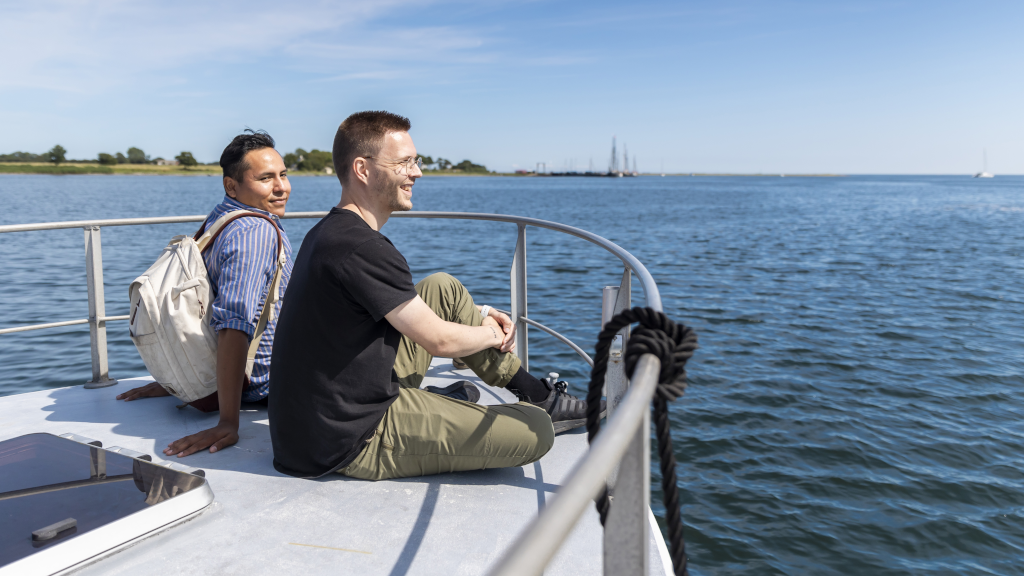 Two men sitting at the bow of the Alrø-Hjarnø Bicycle Ferry