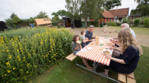 En familie spiser frokost i haven hos Glud Museum