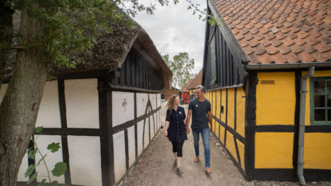 Et par går mellem to bindingsværkshuse på Glud Museum